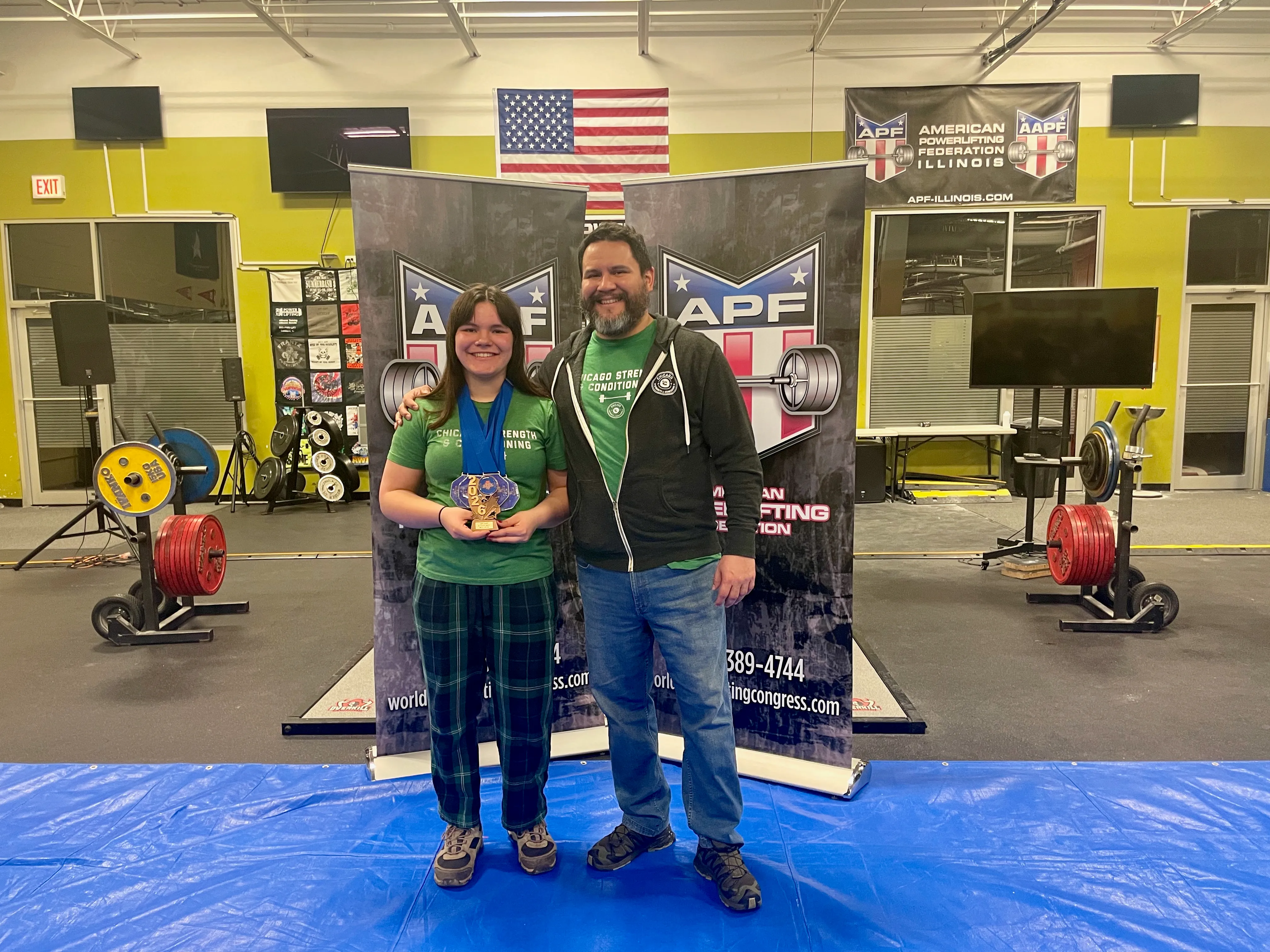 Audrey and her coach David Abdemoulaie after the 2026 Illinois State Championships, where she set national records and won Best Lifter Teen.