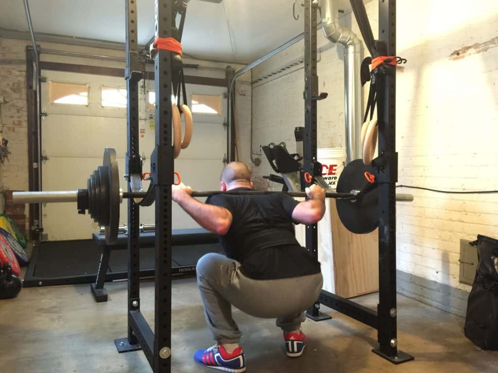 Lifter in the low bar squat position with a tight upper back setup
