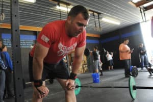 Athletes training with barbells in a CrossFit-style workout